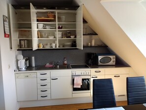 A compact kitchen with a microwave, coffee maker, and a sink. - Domizil Domblick Speyer City - 50qm - Garage - ruhige Lage (Speyer)