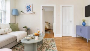 Ein gemütliches Wohnzimmer mit einer Couch, einem Couchtisch und einem floralen Teppich.