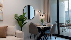 A modern dining area with a round table, chairs, and a large mirror. - Modern 1BR w/ Balcony | Maryah Vista Retreat (Abu Dhabi)