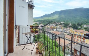 Un balcón con vistas a un pueblo y montañas.