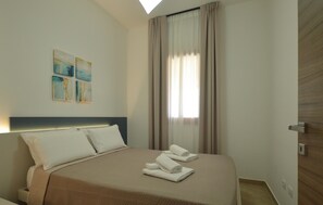 A hotel room with a bed, pillows, a headboard, a window with curtains, and a wall with abstract art. - 2 bedroom nice home in Balestrate (Balestrate)