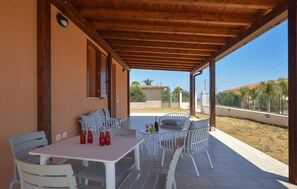 An outdoor patio with a wooden ceiling, white furniture, and a view of the surrounding area. - 2 bedroom nice home in Balestrate (Balestrate)
