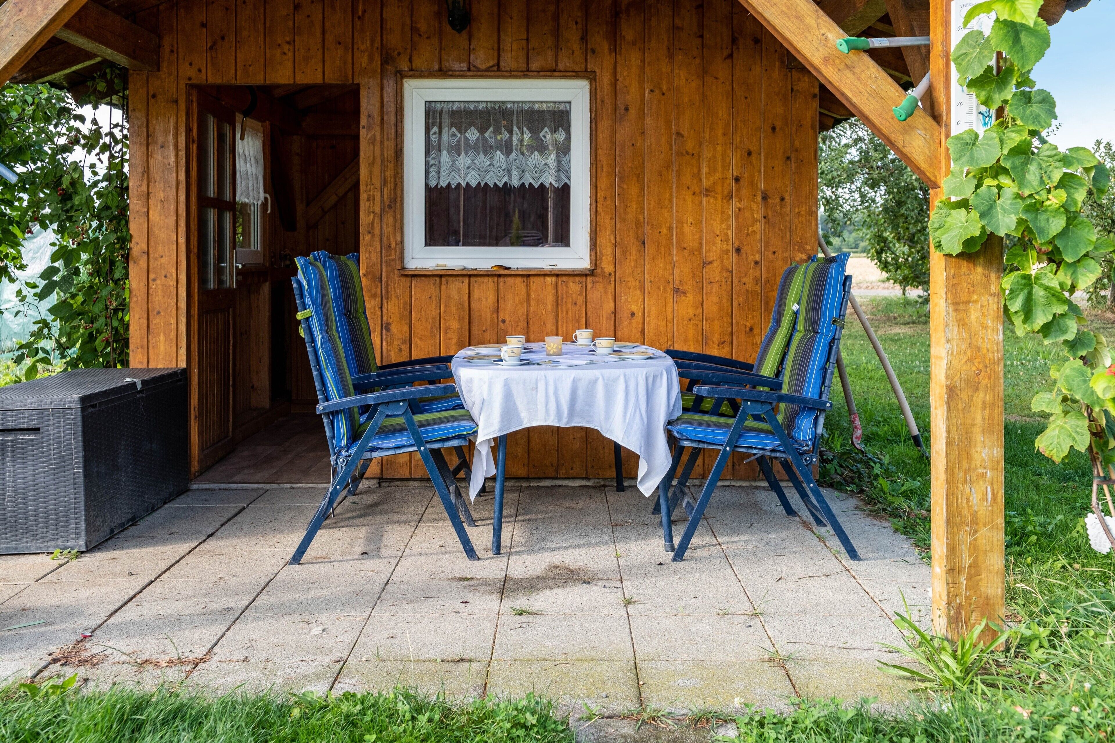 Eine Holzhütte mit Tisch und Stühlen im Freien.