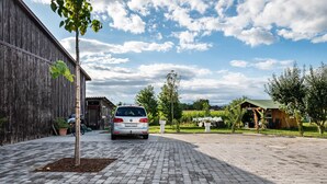 En asfalterad uppfart leder fram till en byggnad där en bil står parkerad framför.