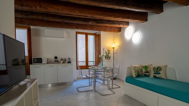 A compact living space with a kitchenette, a dining area, and a seating area with a sofa.
