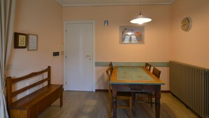 Ein Essbereich mit Holztisch und -stühlen, einer Bank, einer Tür und einer Heizung.