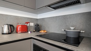 Una cocina moderna con estufa integrada, hervidor, tostadora y cafetera.