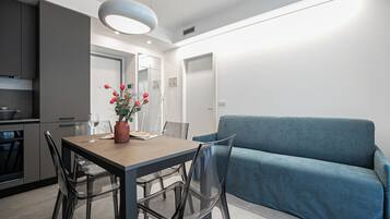 Una cocina moderna con una mesa de comedor, sillas y un florero con flores.