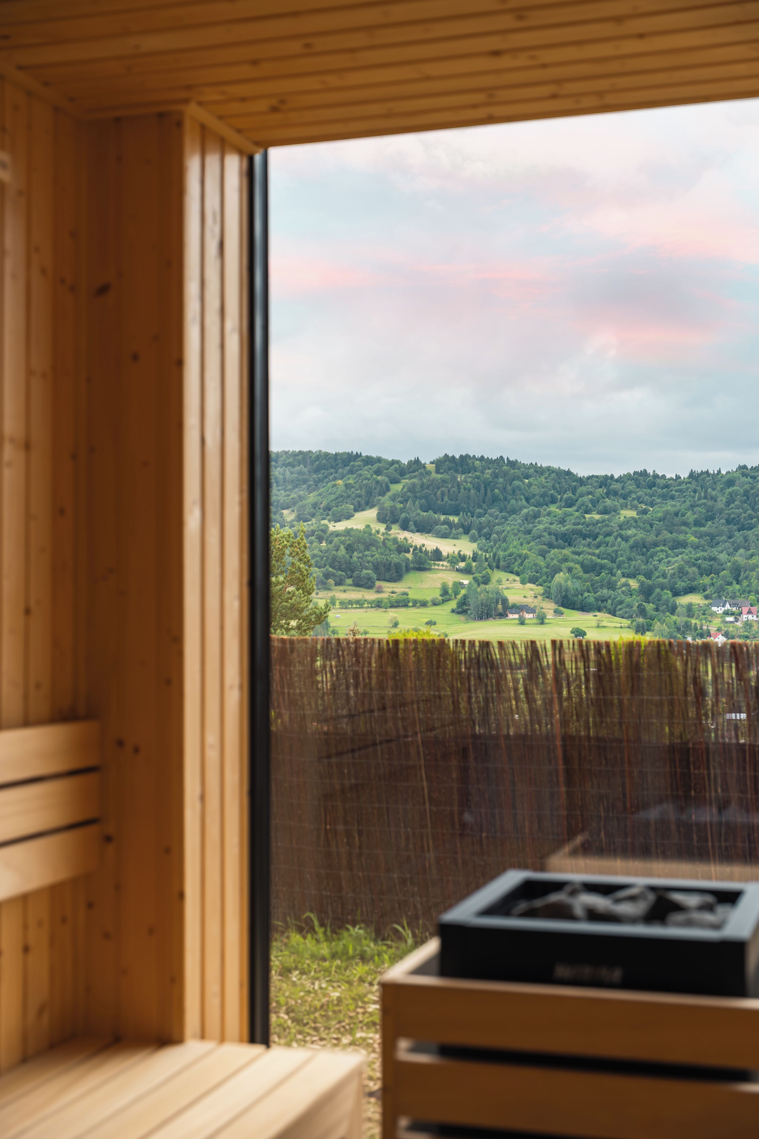 A wooden interior with a view of a green landscape through a window.