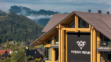 Un edificio moderno con un logotipo destacado, rodeado de un paisaje montañoso.