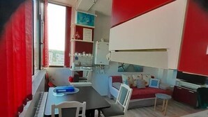 A compact living space with a dining area, kitchenette, and seating area. - Cozy 1-bedroom apartment in gorgeous Constanta with AC (Constanta)