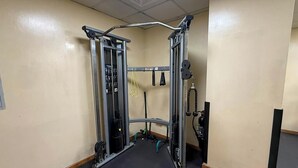A gym with a pull-up bar, weight stack, and various exercise equipment. - Marina Studio Pool View Walk to JBR (Dubai)