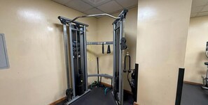 Ein Fitnessstudio mit Klimmzugstange, Gewichte-Kasten und verschiedenen Trainingsgeräten.