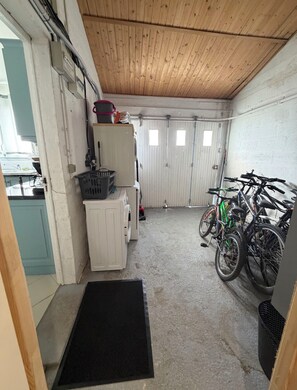 Eine Garage mit Waschmaschine, Trockner und Fahrrädern.