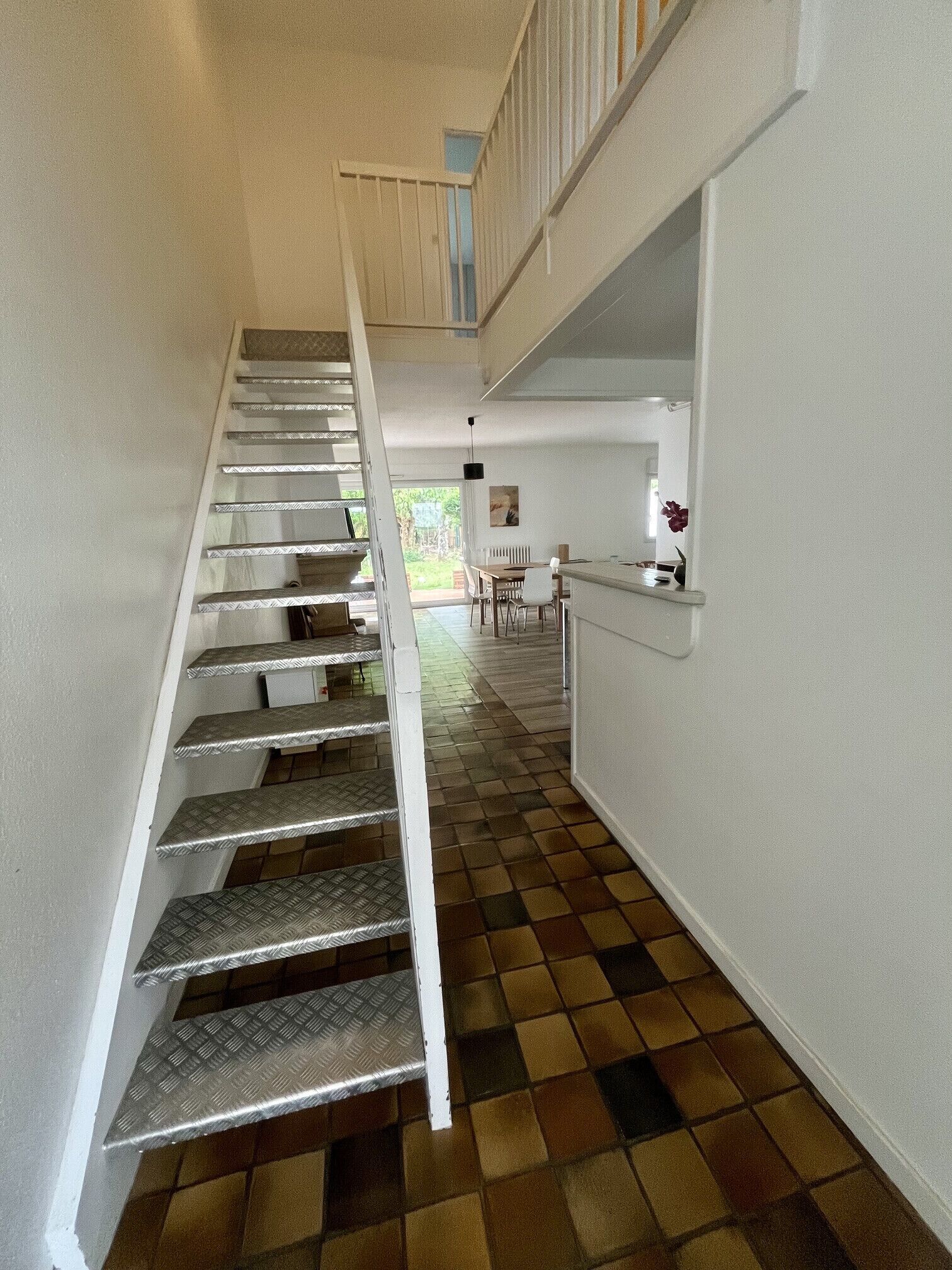 A staircase with a checkered floor leading to a second-floor landing.