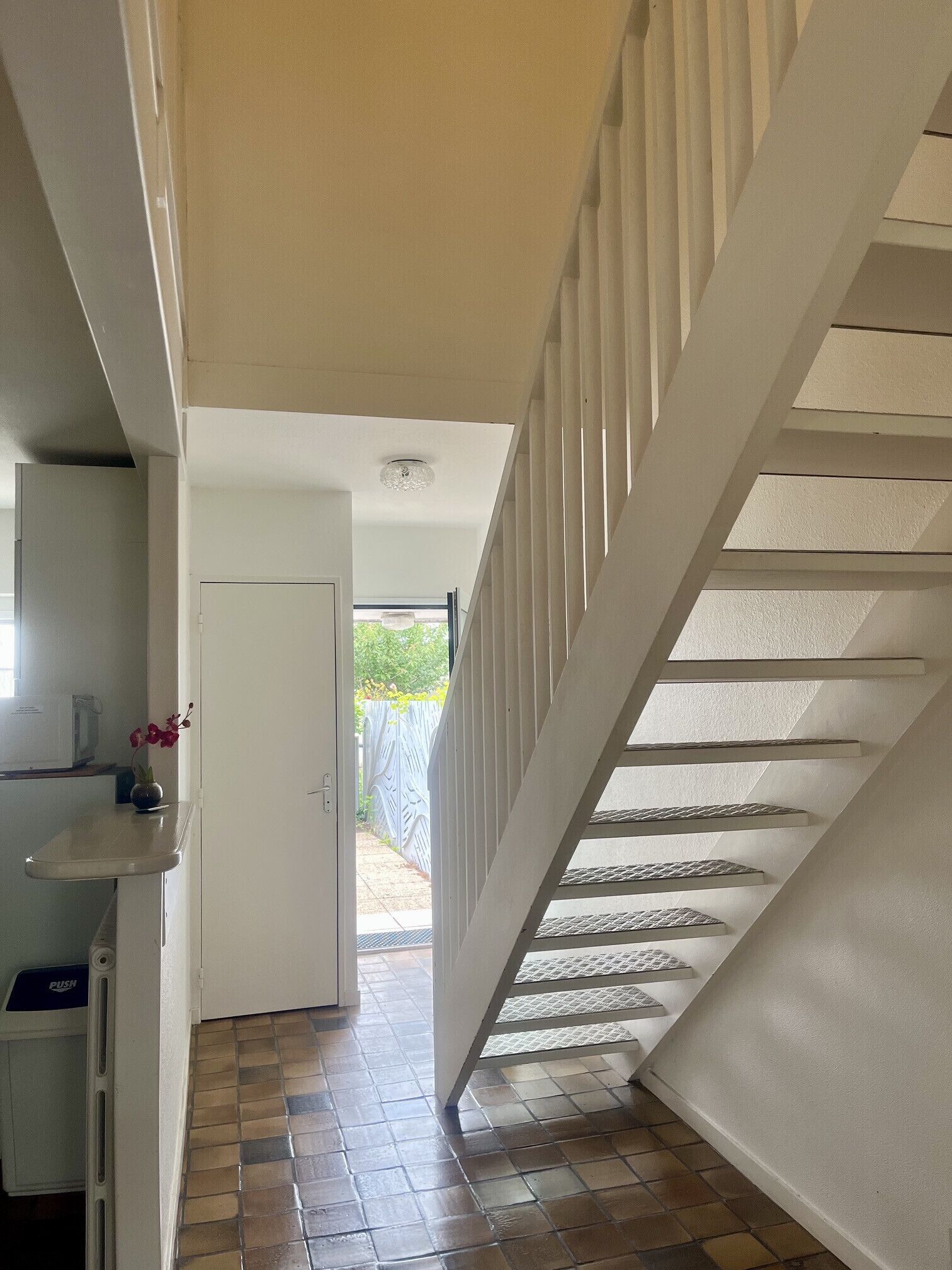 A hallway with a staircase leading to an outdoor area.