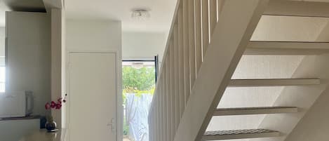 A hallway with a staircase leading to an outdoor area.
