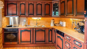 A kitchen with wooden cabinets, a stainless steel range hood, a sink, and a dishwasher. - Stunning home in Bjorli with WiFi (Bjorli)