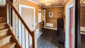 Ein Holzinnenraum mit einer Treppe, einem Kamin und einer Wandheizung.