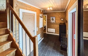 Ein Holzinnenraum mit einer Treppe, einem Kamin und einer Wandheizung.