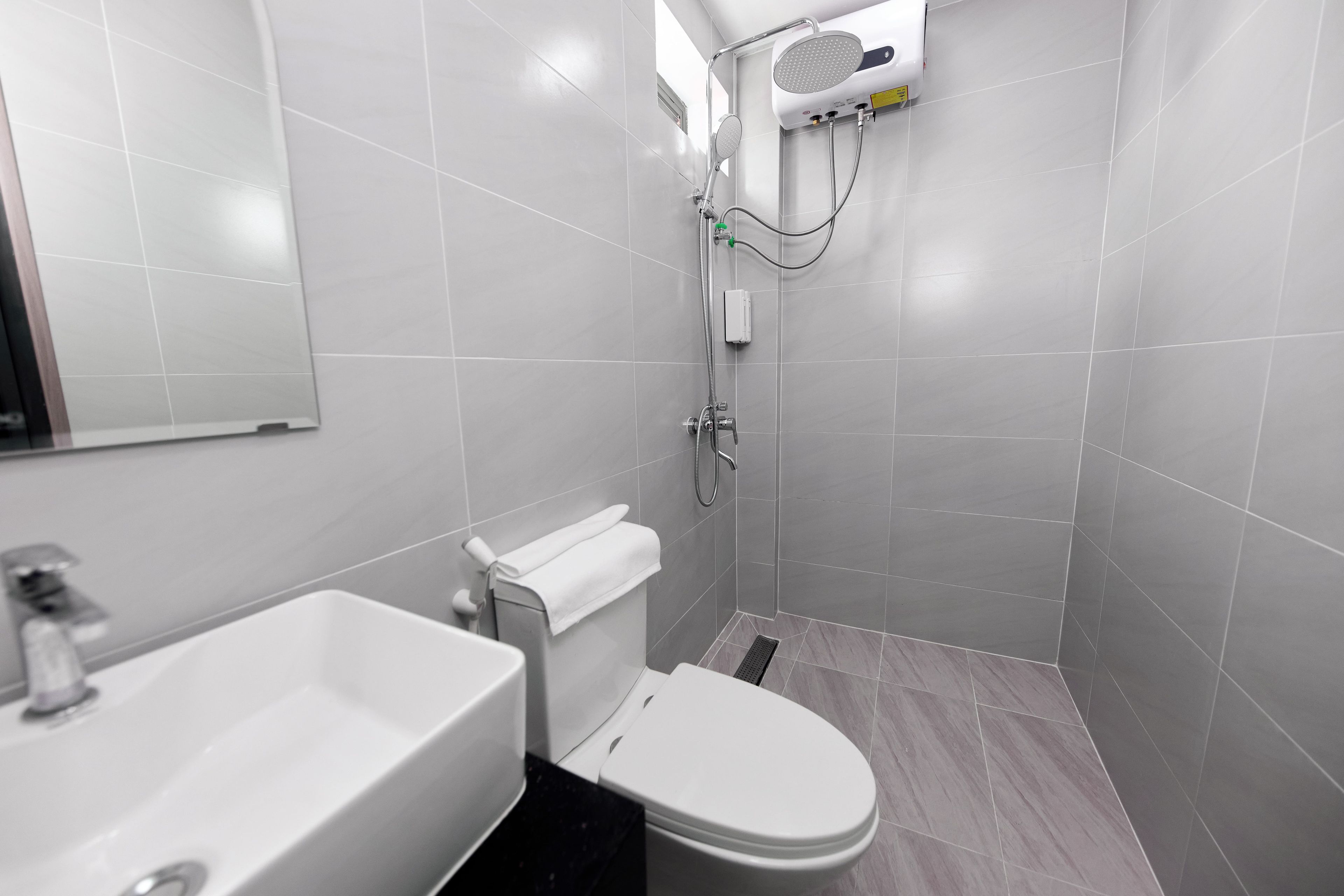 Een moderne badkamer met toilet, wastafel en douche.