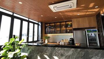 A modern kitchen with a wooden ceiling, marble countertops, and a built-in refrigerator.
