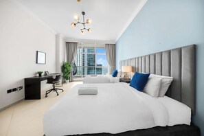 A modern hotel room with a large bed, a desk, and a view of the cityscape. - StayShort - Elegant 4 Bedroom in Dubai Marina that Sleeps 10 (Dubai)