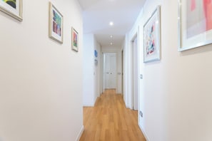 A hallway with wooden flooring, white walls, and framed artwork. - Apartment in Milan with 2 bedrooms sleeps 4 (Milan)