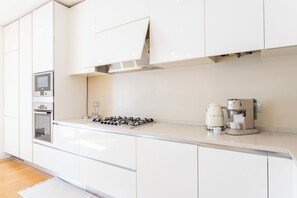 A modern kitchen with white cabinetry, a built-in oven, a gas stove, and a coffee machine. - Apartment in Milan with 2 bedrooms sleeps 4 (Milan)