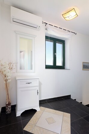 A bathroom with a white vanity, a window with a green frame, a white air conditioning unit, and a light fixture above the window. - Island Krk Villa Niko PET FRIENDLY 200meters from hidden sandy beachPET FRIENDLY (Krk)