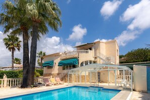 A two-story building with a swimming pool, palm trees, and a clear blue sky. - Casa Nuestro Sue o Para 4 Personas (Calpe)
