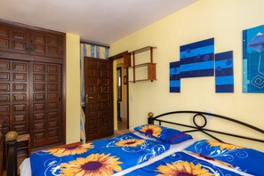 Um quarto com uma cama, um guarda-roupa e uma porta.