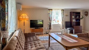 A living room with a sofa, a coffee table, a television, a bookshelf, and a lamp. - Cozy home in Tranås with WiFi (Tranås)