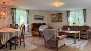 A cozy living room with a dining table, two sofas, a patterned rug, and a chandelier. - Cozy home in Tranås with WiFi (Tranås)