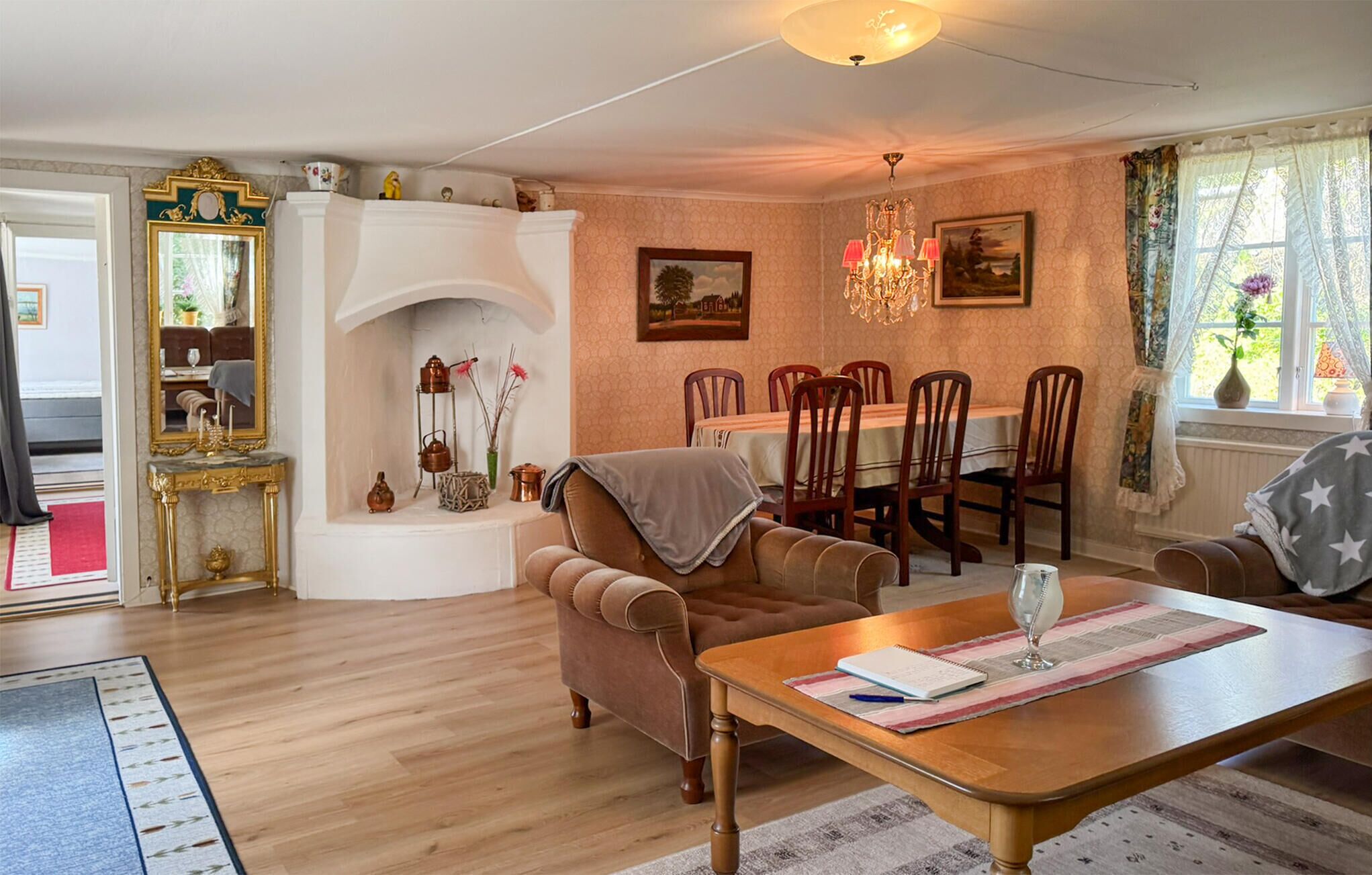 Uma sala de estar com lareira, mesa de jantar e cadeiras.