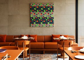 Un comedor moderno con sofá, mesas y sillas.