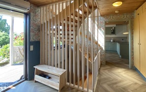 A room with a wooden floor, a built-in bench, a staircase, and a view of a garden. - Amazing home in Kalmar with WiFi (Kalmar)