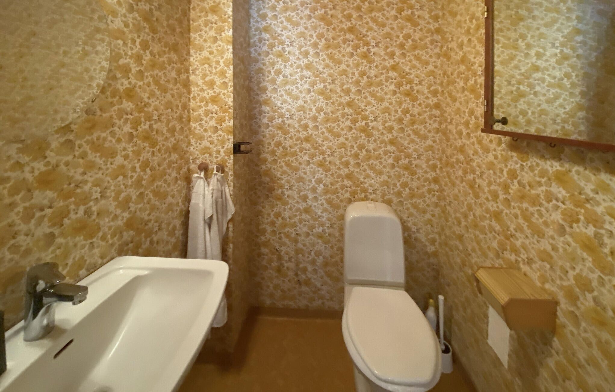 Ein Badezimmer mit Waschbecken, Toilette und Handtuchhalter.