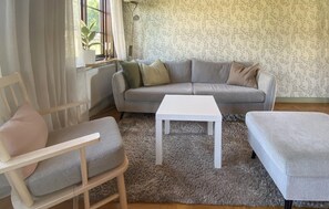 A living room with a grey sofa, a white coffee table, and a grey armchair. - Amazing home in Kalmar with WiFi (Kalmar)