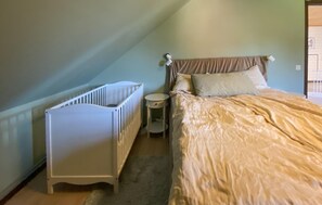 A bedroom with a crib, a bed with a headboard, and a bedside table. - Amazing home in Kalmar with WiFi (Kalmar)