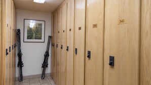 A row of wooden lockers with numbers 334 and 341 visible, and a framed picture of a forest on the wall. - Ski In/Out|Hot Tub|Great Views|Walk to Base Area (Steamboat Springs)