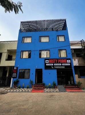 A multi-story building with a blue facade, featuring a sign for 'MISTY PRIME' which advertises AC rooms, a restaurant, and a banquet hall. - Hotel Misty Prime (Indore)