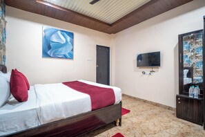 A hotel room with a bed, a painting, a television, and a mirror. - Hotel Misty Prime (Indore)