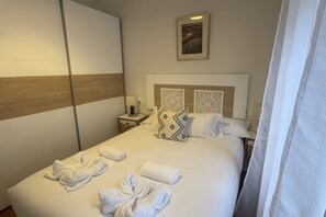 Ein Hotelzimmer mit einem Bett, einem Nachttisch, einer Lampe und einem gerahmten Bild an der Wand.