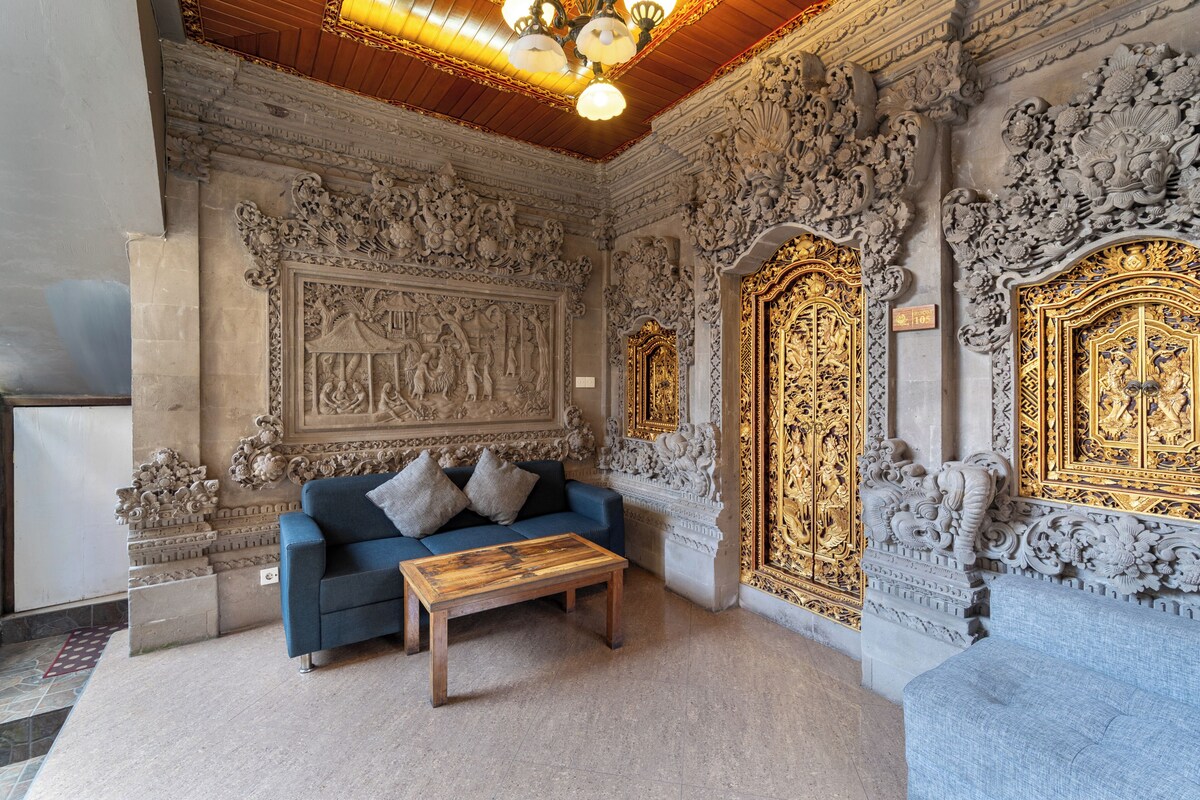 A room with ornate carvings, a blue sofa, and a wooden coffee table.