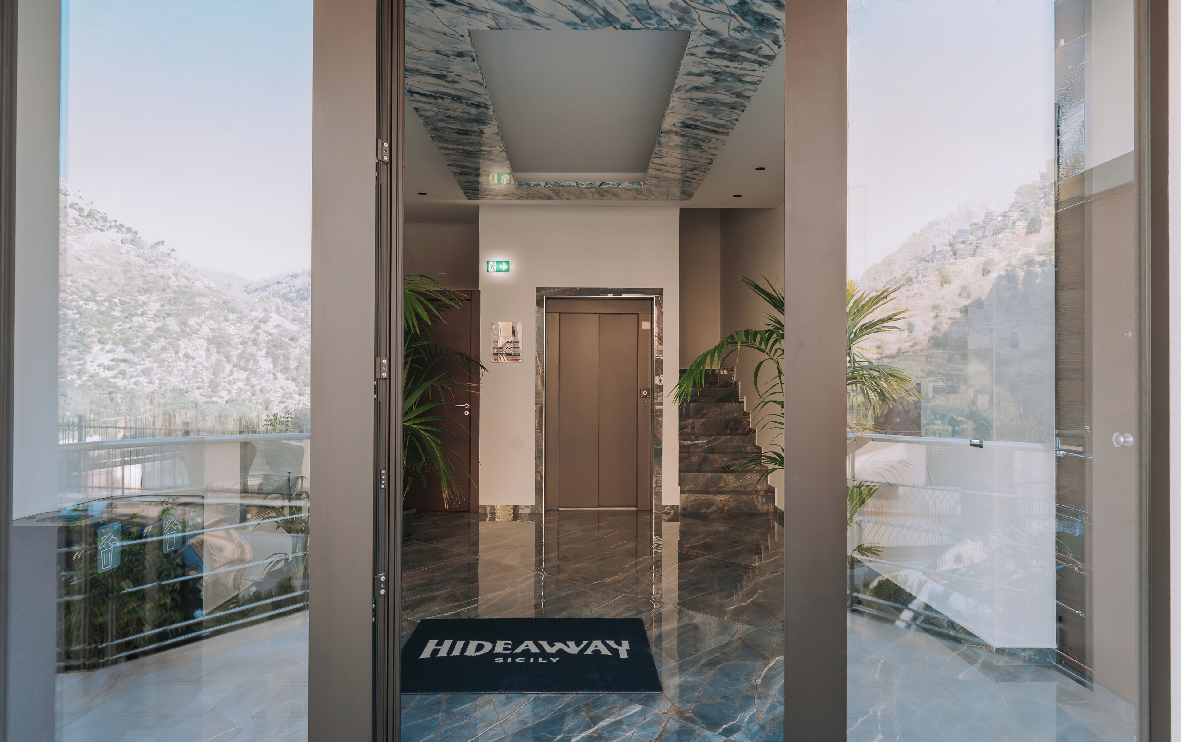 L'ingresso di un hotel con pavimento in marmo, una porta e vista sulle montagne.