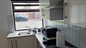 Eine moderne Küche mit Fenster, Spüle und Edelstahlgeräten.