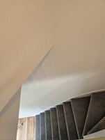 A staircase with a wooden finish and a white ceiling.