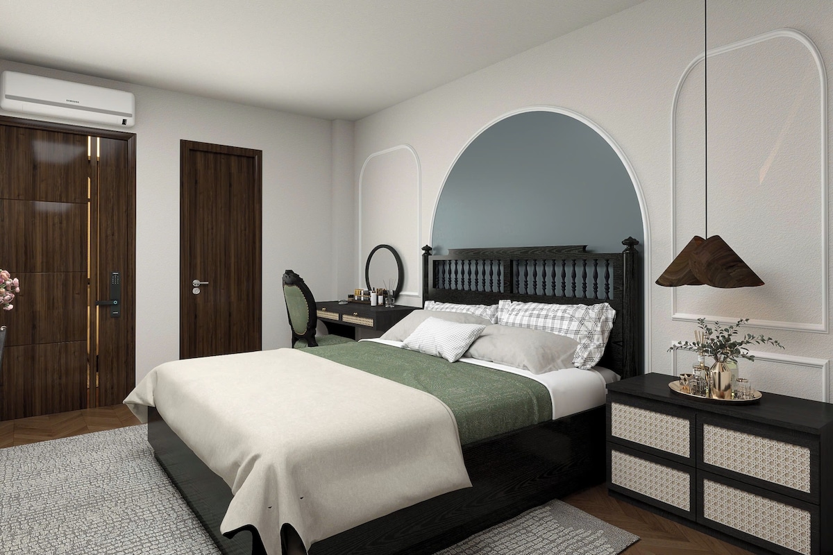 A bedroom with a bed, bedside table, dresser, and a mirror.