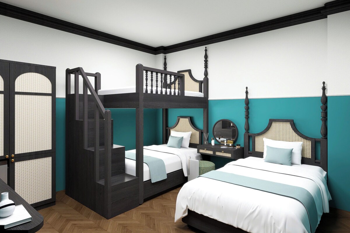 A room with a bunk bed, a desk, and a nightstand.